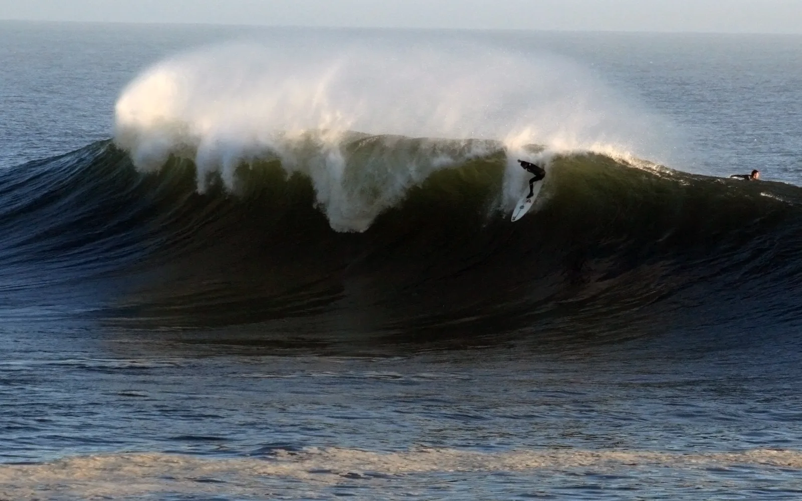 A large wave breaking against cliffs on the Santa Cruz coast